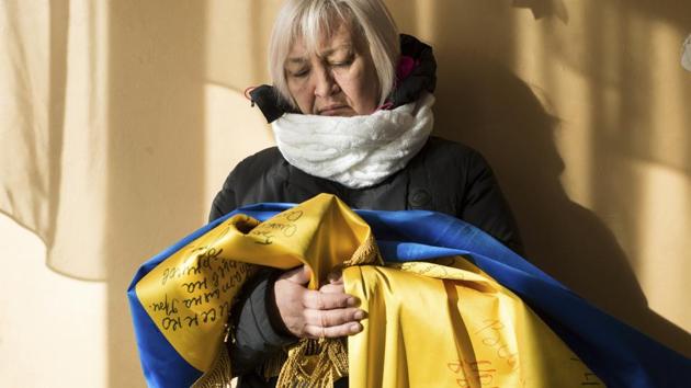 Tetyana Borisenko, former medical worker for Ukrainian volunteers 'Aydar Battalion', holds the Ukrainian flag she brought to the school in her home in Voznesenske village, Ukraine. Borisenko was captured by Russia-backed separatists in the Luhansk region in September 2015. She was able to secretly keep a Ukrainian flag with signatures of 12 people she was in captivity with for a month. (Zoya Shu / AP)