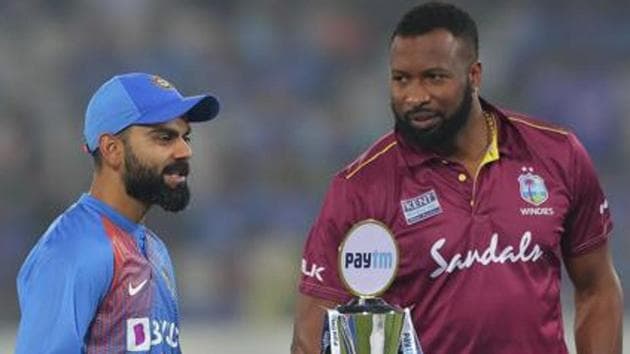 India's captain Virat Kohli, left, interacts with West Indies' captain Kieron Pollard as they pose with the series trophy.(AP)