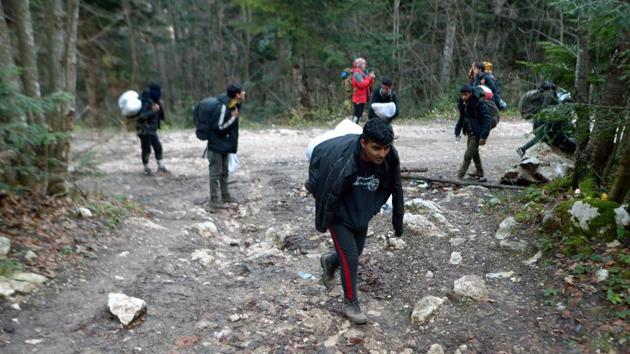 Illegal migrants walk on a forest trail towards the Croatian border, after leaving the Vucjak camp. Some 8,000 migrants are currently in Bosnia, whose official UN-run migrant centres can hold up to 5,000 people. (Elvis Barukcic / AFP)