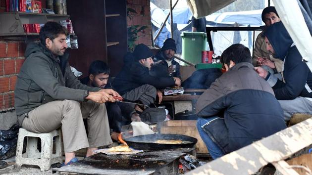 Migrants sit around an improvised stove as they prepare their food at the Vucjak camp. At the camp, a cluster of tents that lack running water, heating or proper toilets, was set up close to the border in June. The site immediately drew international criticism for being on top of a landfill, in an area littered with mines from the 1990s Balkans war. (Elvis Barukcic / AFP)