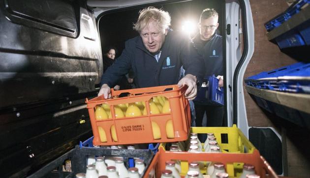 Britain's Prime Minister Boris Johnson loads a crate into a milk delivery van during a visit to Greenside Farm Business Park, as he campaigns for votes on the last day of campaigning ahead of Thursday's General Election, in Leeds, England, early Wednesday Dec. 11, 2019. (AP photo) Britain's Prime Minister Boris Johnson loads a crate into a milk delivery van during a visit to Greenside Farm Business Park, as he campaigns for votes on the last day of campaigning ahead of Thursday's General Election, in Leeds, England, early Wednesday Dec. 11, 2019. (AP photo)