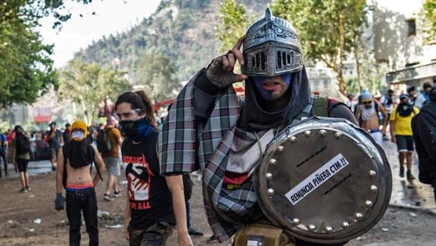 A demonstrator wearing a helmet uses a makeshift shield during a protest. For some, the protest movement has been the downfall of a country that was often described as a regional bastion of stability and prosperity but is now suffering from chaos inflicted by hooded anarchists and looters. For others, the mass demonstrations are a festival of rebirth. (Martin BERNETTI / AFP) A demonstrator wearing a helmet uses a makeshift shield during a protest. For some, the protest movement has been the downfall of a country that was often described as a regional bastion of stability and prosperity but is now suffering from chaos inflicted by hooded anarchists and looters. For others, the mass demonstrations are a festival of rebirth. (Martin BERNETTI / AFP)