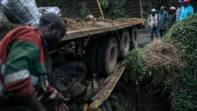 Crew members of a transport truck attempt to pull their vehicle on the road from Goma to Kitshanga. The government faces a daunting challenge to protect the rainforest. Its 2002 forestry code imposed a moratorium on new concessions and regulated the number of trees that could be chopped down under existing permits, but officials complain of a lack of resources. Felicien Malu, a provincial environment coordinator, has roughly 1,200 workers to cover a province twice the size of Portugal.  (ALEXIS HUGUET / AFP) 