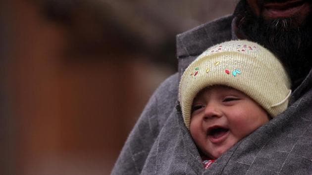 A man carries an infant on a cold winter day in a village of south Kashmir's Pulwama.(REUTERS)