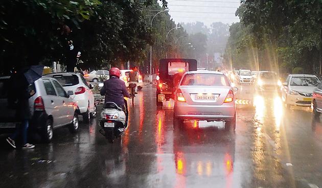 With the sky becoming dark pretty early amid cloud cover, motorists switch on the headlights during the downpour at Panjab University in Chandigarh on Friday.(HT PHOTO)