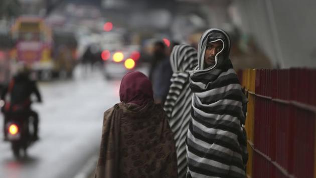 Pedestrians cover themselves as they take shelter under a flyover bridge from rain in Jammu on Friday. (AP Photo) Pedestrians cover themselves as they take shelter under a flyover bridge from rain in Jammu on Friday. (AP Photo)