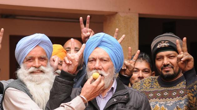 Relatives and neighbourers offering sweets to Amrik Singh, uncle of Tanmanjeet Singh Dhesi, at their native village near Jalandhar on Friday.(Pardeep Pandit/HT)