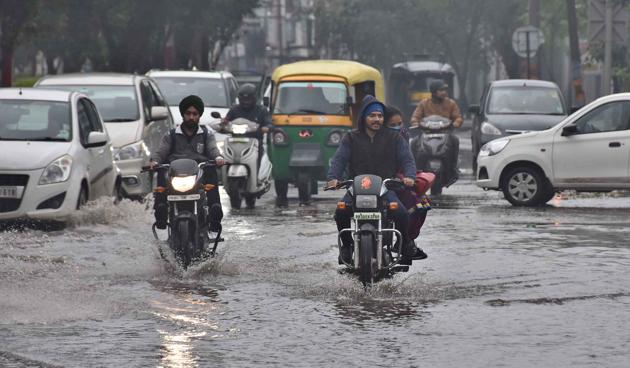 Commuters wade through a waterlogged road in Haibowal in Ludhiana on Friday. (Harsimar Pal Singh/HT) Commuters wade through a waterlogged road in Haibowal in Ludhiana on Friday. (Harsimar Pal Singh/HT)