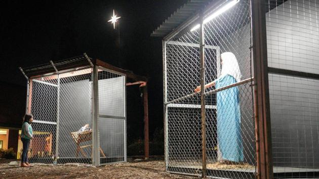 A child seen standing near the sculptures of Jesus and Mary, depicted as refugees in cages, which form part of a Nativity scene at Claremont United Methodist Church in Claremont, California, U.S. (Kyle Grillot / REUTERS)