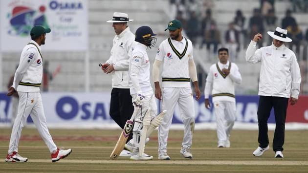 England's umpire Richard Kettlevorough, right, gestures to stop the game due to bad lights. (AP) England's umpire Richard Kettlevorough, right, gestures to stop the game due to bad lights. (AP)