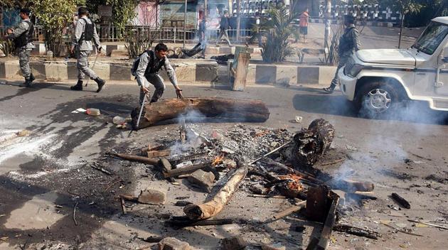 Paramilitary personnel removing the blockade after a protest against citizenship law in Guwahati on Thursday.(ANI Photo)