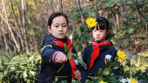 Students place flowers in front of a memorial to mark the annual national day of remembrance to commemorate the 82nd anniversary of Nanjing massacre during a memorial ceremony in Nanjing in China's eastern Jiangsu province. (STR / AFP / China OUT)