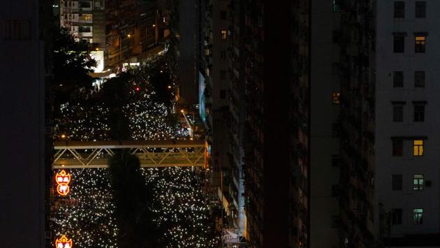 People raise their phone lights as they take part in a pro-democracy rally in Wan Chai in Hong Kong. The march was organised by the Civil Human Rights Front after it was granted approval by the police. The group had organised two of the largest peaceful protests early in the moment back in July. (Alastair Pike / AFP)