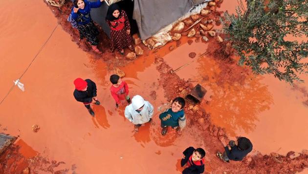 Aerial view shows children walking at a flooded camp for displaced Syrians near the village of Killi in the north of the northwestern Idlib province. (Abdulaziz KETAZ / AFP)
