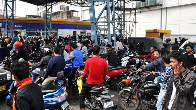 Commuters wait at a petrol pump during curfew relaxation in Guwahati.(ANI)