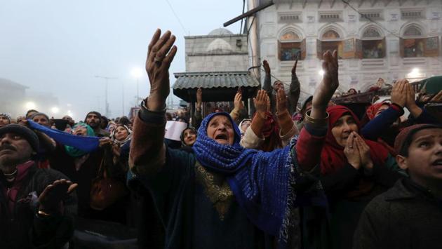 Devotees react while praying as a priest displays the relic of Sheikh Syed Abdul Qadir Jeelani, at his shrine, in Srinagar, Jammu and Kashmir. (Waseem Andrabi / HT Photo)