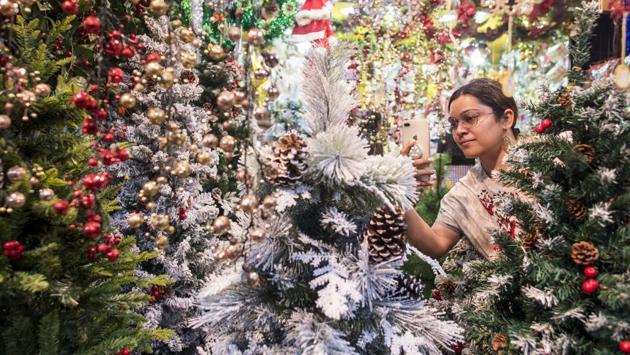A woman clicks a picture of a Christmas tree ahead of Christmas at Bandra, in Mumbai. (Satyabrata Tripathy / HT Photo)