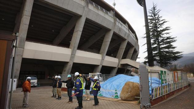 Workers chant slogan during a morning gathering outside the Azuma Baseball Stadium, a venue for baseball and softball at the Tokyo 2020. Nobody perished from the immediate impact of radiation in Fukushima, but more than 40 elderly patients died after they were forced to travel long hours on buses to out-of-town evacuation centers. Their representatives filed criminal complaints and eventually sent former Tokyo Electric Power Company executives to court. They were acquitted. (Jae C. Hong / AP)