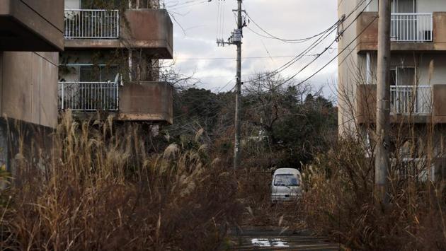 Weeds grow in an abandoned apartment complex. “This recovery Olympics is in name only,” Toshihide Yoshida said. He was forced to abandon Futaba and ended up living near Tokyo. “The amount of money spent on the Olympics should have been used for real reconstruction.” (Jae C. Hong / AP)