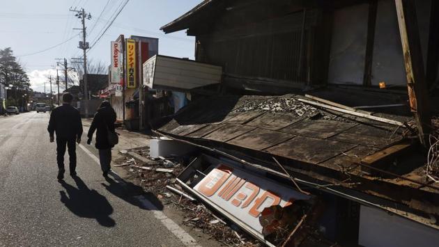 Former town officials and evacuees Osumi Muneshige, left, walks with Yukimi Itakura as they visit the abandoned town of Futaba. The radiation that spewed from the plant at one point displaced more than 160,000 people. Futaba is the only one of 12 radiation-hit towns that remains a virtual no-go zone. Only daytime visits are allowed for decontamination and reconstruction work, or for former residents to check their abandoned homes. (Jae C. Hong / AP)