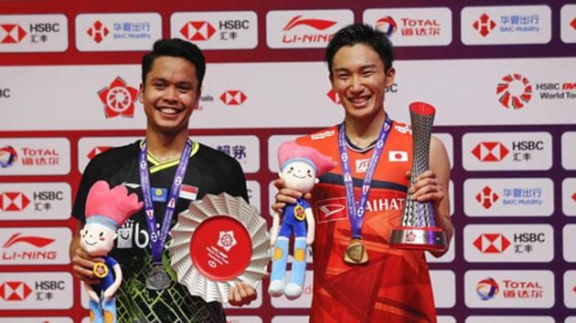 Kento Momota of Japan, right, and runner-up Anthony Sinisuka pose with their trophies after their men's singles badminton final match at the World Tour Finals in Guangzhou.(AP)