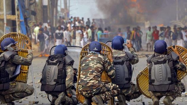 Police jawans try to protect themselves as protestors throw stones on them during an agitation against the Citizenship Amendment Bill (CAB) at Santragachi in Howrah district of West Bengal on Dec 14, 2019. (PTI) Police jawans try to protect themselves as protestors throw stones on them during an agitation against the Citizenship Amendment Bill (CAB) at Santragachi in Howrah district of West Bengal on Dec 14, 2019. (PTI)