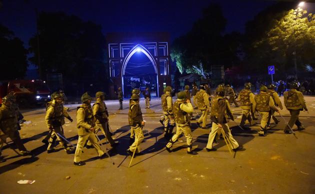 Policemen stand guard near Jamia Millia Islamia following the protests against the new citizenship law in New Delhi on Sunday. (PTI Photo) Policemen stand guard near Jamia Millia Islamia following the protests against the new citizenship law in New Delhi on Sunday. (PTI Photo)