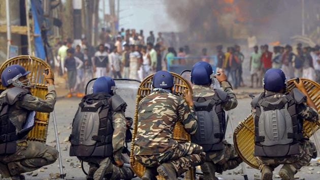 Police jawans try to protect themselves as protestors throw stones on them during an agitation against the Citizenship Amendment Bill (CAB) at Santragachi in Howrah district of West Bengal, Saturday, Dec 14, 2019. (PTI) Police jawans try to protect themselves as protestors throw stones on them during an agitation against the Citizenship Amendment Bill (CAB) at Santragachi in Howrah district of West Bengal, Saturday, Dec 14, 2019. (PTI)