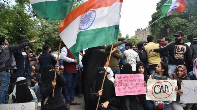 Protesters holding placards and a national flag during a protest over the Citizenship Amendment Act near Jamia Nagar in New Delhi. (ANI Photo) Protesters holding placards and a national flag during a protest over the Citizenship Amendment Act near Jamia Nagar in New Delhi. (ANI Photo)