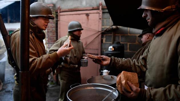 Actors wearing WWII US uniforms stand in a canteen as they take part in a historical re-enactment of the Battle of the Ardennes. Germany is now an ally of the United States and its wartime partners in NATO. During the poignant ceremonies at the star-shaped Mardasson memorial in Bastogne, the current discord between the United States and several European allies over trade and security were never mentioned. (John Thys / AFP) Actors wearing WWII US uniforms stand in a canteen as they take part in a historical re-enactment of the Battle of the Ardennes. Germany is now an ally of the United States and its wartime partners in NATO. During the poignant ceremonies at the star-shaped Mardasson memorial in Bastogne, the current discord between the United States and several European allies over trade and security were never mentioned. (John Thys / AFP)