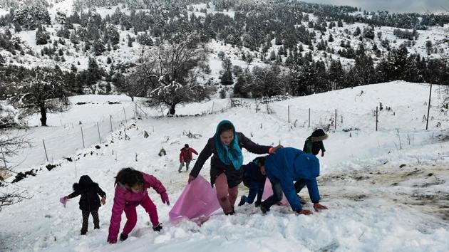 Migrant children play in the snow by a disused ski lodge near the village of Polineri. According to government figures, there are now over 40,000 people on these islands, with more than 37,000 of them in camps built to handle just over 6,000. Amid rising anger on the islands, the conservative government of Prime Minister Kyriakos Mitsotakis recently promised to relocate 20,000 asylum-seekers to other facilities on the mainland by the end of the year. (Sakis Mitrolidis / AFP) Migrant children play in the snow by a disused ski lodge near the village of Polineri. According to government figures, there are now over 40,000 people on these islands, with more than 37,000 of them in camps built to handle just over 6,000. Amid rising anger on the islands, the conservative government of Prime Minister Kyriakos Mitsotakis recently promised to relocate 20,000 asylum-seekers to other facilities on the mainland by the end of the year. (Sakis Mitrolidis / AFP)