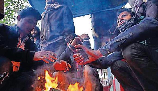 Men gather around a bonfire to warm themselves from mornign cold waves at Jhandewalan in New Delhi, India, on Tuesday, December 17, 2019. (Photo by Sanchit Khanna/HT Photo) Men gather around a bonfire to warm themselves from mornign cold waves at Jhandewalan in New Delhi, India, on Tuesday, December 17, 2019. (Photo by Sanchit Khanna/HT Photo)