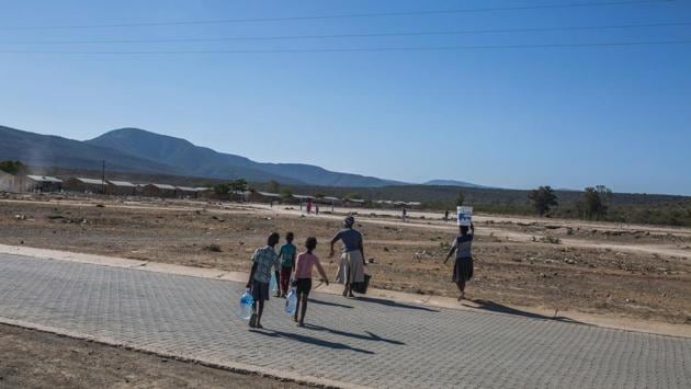 A family carries bottles of water in the Bezuidenhoudtville informal settlement. On nearby farms, high-yielding avocado trees now barely produce 10, low-grade fruit instead of 50. Helpless farmers watch their animals succumb to thirst and hunger. “I can’t sleep at night,” said the retired farmer. Bothma feared that more months without rain would force him “to close the books”. “Farmers are taking their life,” he said, eyes reddened by the dust. (Guillem Sartorio / AFP) A family carries bottles of water in the Bezuidenhoudtville informal settlement. On nearby farms, high-yielding avocado trees now barely produce 10, low-grade fruit instead of 50. Helpless farmers watch their animals succumb to thirst and hunger. “I can’t sleep at night,” said the retired farmer. Bothma feared that more months without rain would force him “to close the books”. “Farmers are taking their life,” he said, eyes reddened by the dust. (Guillem Sartorio / AFP)