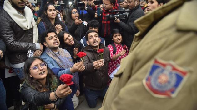 Protestors offer roses to policemen during a demonstration against the Citizenship (Amendment) Act,at Mandi House, New Delhi.(PTI)
