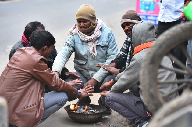 People warm themselves near a bonfire on a cold winter day, near Ganesh Nagar, in New Delhi, India, on Wednesday, December 18, 2019. (Raj K Raj/HT PHOTO) People warm themselves near a bonfire on a cold winter day, near Ganesh Nagar, in New Delhi, India, on Wednesday, December 18, 2019. (Raj K Raj/HT PHOTO)