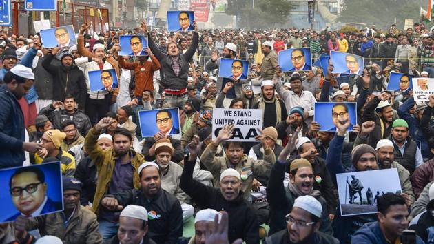 Protestors hold placards during a demonstration against the Citizenship Amendment Act (CAA) at Jamia Nagar in New Delhi,. (PTI)