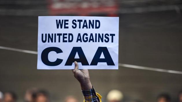 A protestor holds a placard during a demonstration against the Citizenship Amendment Act (CAA) at Jamia Nagar in New Delhi. (PTI)