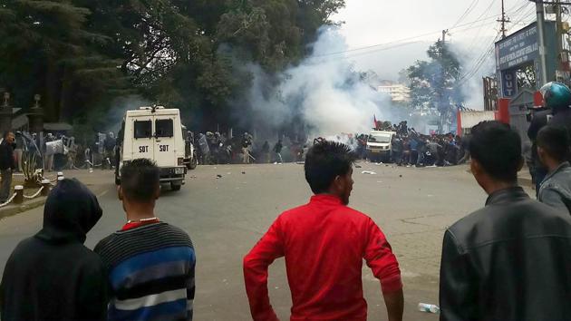 Onlookers watch from a distance as protestors clash with security personnel during a demonstration against the passing of Citizenship Amendment Bill, infront of Raj Bhavan in Shillong, Meghalaya last week. (PTI) Onlookers watch from a distance as protestors clash with security personnel during a demonstration against the passing of Citizenship Amendment Bill, infront of Raj Bhavan in Shillong, Meghalaya last week. (PTI)