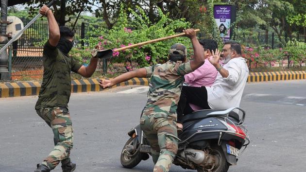 Members of the Karnataka Reserve Police Force swing their sticks to beat two men on a scooter who rode too close to a barricade set up on a street in Mangalore, Karnataka, amid heightened security due to protests against CAA. National Highways were blocked and state-run buses from Karnataka stopped at many places of Kerala on Friday by anti-CAA protesters, even as journalists, students and political party activists took out rallies against implementation of CAA. (AFP) Members of the Karnataka Reserve Police Force swing their sticks to beat two men on a scooter who rode too close to a barricade set up on a street in Mangalore, Karnataka, amid heightened security due to protests against CAA. National Highways were blocked and state-run buses from Karnataka stopped at many places of Kerala on Friday by anti-CAA protesters, even as journalists, students and political party activists took out rallies against implementation of CAA. (AFP)