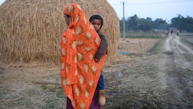 A woman holds her child next to farming fields in Barpeta. Those who cannot prove their Indian citizenship will either end up in detention centres or hide from authorities all their life. (Sajjad Hussain / AFP) A woman holds her child next to farming fields in Barpeta. Those who cannot prove their Indian citizenship will either end up in detention centres or hide from authorities all their life. (Sajjad Hussain / AFP)