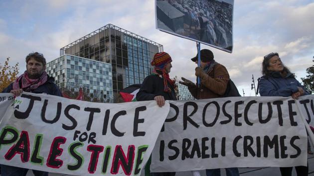 Demonstrators carry banners outside the International Criminal Court, ICC, rear, urging the court to prosecute Israel's army for war crimes in The Hague, Netherlands.(AP) Demonstrators carry banners outside the International Criminal Court, ICC, rear, urging the court to prosecute Israel's army for war crimes in The Hague, Netherlands.(AP)