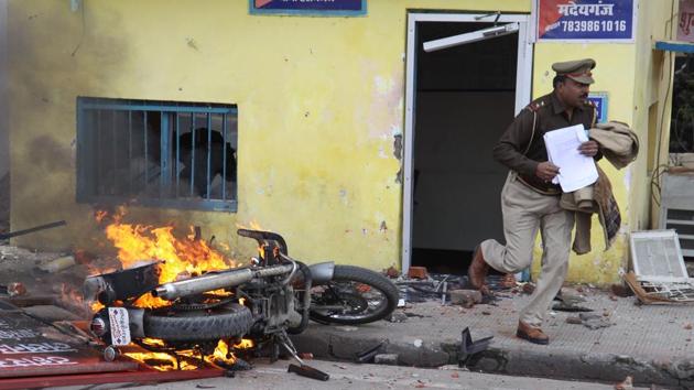 In this picture taken on Thursday, an officer runs with documents from a police post damaged by protesters during a demonstration against CAA in Lucknow, Uttar Pradesh. Tension simmered in several cities—Kanpur, Gorakhpur, Deoband (Saharanpur), Muzaffarnagar, Hapur, Shamli, Prayagraj, Bulandshahr, Meerut, Firozabad and Varanasi—as thousands defied pleas by authorities to exercise restraint a day after large-scale violence was reported across the state. (AFP) In this picture taken on Thursday, an officer runs with documents from a police post damaged by protesters during a demonstration against CAA in Lucknow, Uttar Pradesh. Tension simmered in several cities—Kanpur, Gorakhpur, Deoband (Saharanpur), Muzaffarnagar, Hapur, Shamli, Prayagraj, Bulandshahr, Meerut, Firozabad and Varanasi—as thousands defied pleas by authorities to exercise restraint a day after large-scale violence was reported across the state. (AFP)