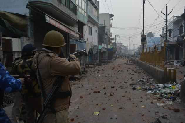 A policeman opening fire at a mob at the other end of a road in Meerut area on Friday.(HT)