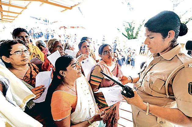A police personnel checks the age proof of women devotees to weed out women in the 10-50 age group at the Pamba base camp of Sabarimala Temple as the shrine opened for Mandala-Makaravilakku pooja in the evening, at Pathanamthitta district of Kerala.(Vivek R Nair / Hindustan Times)