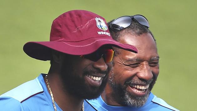 West Indies' captain Kieron Pollard, left, shares a light moment with head coach Phil Simmons.(AP)