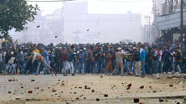 Protesters throw stones on police personnel during a protest in UP’s Aligarh on Friday. Five protesters were hospitalised and the condition of one of them was stated to be critical, District Magistrate (DM) Aunjaneya Singh said. “Over a dozen policemen also suffered minor injuries during stone-pelting by the protesters, including children aged between 12 and 18 years,” he said. (Manoj Aligadi / ANI)