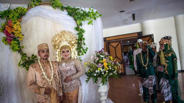 People take part in a mass wedding for sixty couples sponsored by local government social services, in Surabaya, Indonesia. (Juni Kriswanto / AFP) People take part in a mass wedding for sixty couples sponsored by local government social services, in Surabaya, Indonesia. (Juni Kriswanto / AFP)