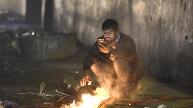 A man sits near a bonfire to warm himself on a cold winter evening, at Connaught Place, in New Delhi, India on Thursday. (Sonu Mehta/HT PHOTO) A man sits near a bonfire to warm himself on a cold winter evening, at Connaught Place, in New Delhi, India on Thursday. (Sonu Mehta/HT PHOTO)