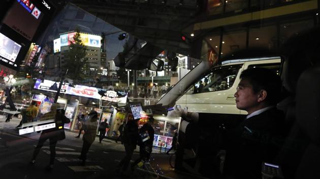 Norihito Arima waits for traffic light to change as he drives along the streets of Tokyo. He drives in a suit and tie. White gloves are optional. Drivers are not allowed to have tattoos or wear sunglasses, and men must be clean-shaven. “It’s something like the army,” Norihito said. (Jae C. Hong / AP) 