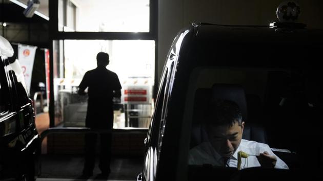 Norihito Arima eats his dinner in his taxi. Norihito said the “damage” occurs a couple of times a year and, under company policy, drivers are told not to collect fares from these customers. He said it’s not easy to avoid the heavy drinkers. With few exceptions, the law requires drivers to pick up customers requesting a ride. Also, it’s impossible to ignore a customer if a reservation has been booked ahead of time. (Jae C. Hong / AP) 